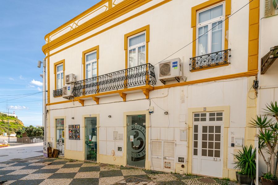 Fachada tradicional e calçada portuguesa numa rua de Albufeira